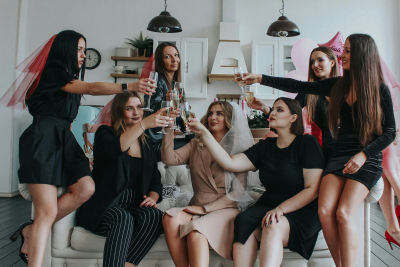 Friends clinking homemade cocktails at a budget hen do